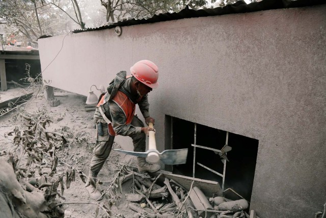 Un soldado usa un pico en un área afectada por la erupción del volcán Fuego en la comunidad de San Miguel Los Lotes en Escuintla, Guatemala el 5 de junio de 2018. REUTERS / Luis Echeverría