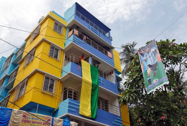 Los fanáticos cuelgan una gran bandera de un edificio residencial junto a un cartel con el futbolista argentino Lionel Messi antes de la Copa Mundial de la FIFA, en Calcuta, India, el 10 de junio de 2018. REUTERS / Rupak De Chowdhuri