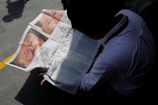 Un periodista lee un periódico local que muestra un artículo sobre la cumbre entre el presidente estadounidense Donald Trump y el líder norcoreano Kim Jong Un cerca del hotel St. Regis en Singapur el 11 de junio de 2018. REUTERS / Tyrone Siu
