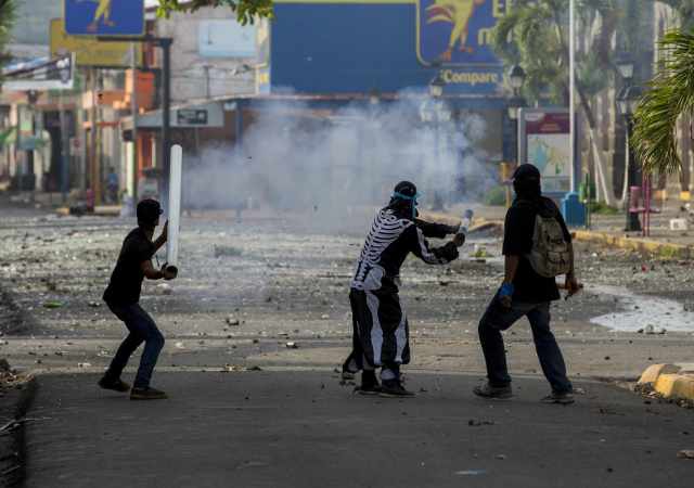 -FOTODELDIA- NI6033. MASAYA (NICARAGUA), 02/06/2018.- Tres jóvenes lanzan un mortero en un enfrentamiento con la Policía Nacional en la ciudad de Masaya (Nicaragua) hoy, sábado 02 de junio de 2018, durante el día número 46 de protestas en contra del gobierno de Daniel Ortega. La Policía de Nicaragua reportó hoy dos muertos, dos heridos y 11 detenidos en el marco de las protestas contra el Gobierno de Daniel Ortega. EFE/Jorge Torres