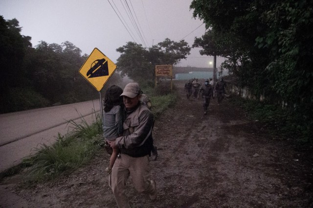  Un policía de Guatemala ayuda a evacuar a una niña en la aldea El Porvenir (Guatemala) hoy, domingo 3 de junio de 2018, luego de la erupción del volcán de Fuego, que ha dejado al menos siete personas fallecidas, 20 heridos y 1,7 millones de afectados, informaron hoy las autoridades de Guatemala. EFE/JOSE MISA