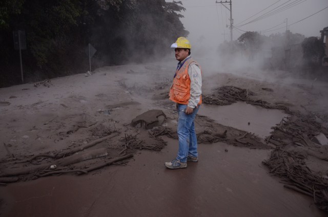 Un trabajador de la Coordinadora Nacional para la Reducción de Desastres (Conred) de Guatemala observa los daños en El Rodeo, Escuintla (Guatemala) hoy, domingo 3 de junio de 2018, luego de la erupción del volcán de Fuego, que ha dejado al menos 25 muertos, 20 heridos y más de 1,7 millones de personas afectadas. EFE/NOE PÉREZ
