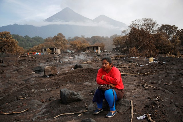 Milvia Vasquez observes an excavator removing ash from the site where she presumes her brothers are buried in an area affected from the eruption of Fuego volcano in San Miguel Los Lotes, in Escuintla, Guatemala June 13, 2018. REUTERS/Luis Echeverria     TPX IMAGES OF THE DAY