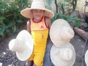 Niño indígena de La Macanilla en Apure vende sombreros de moriche para operarse labio leporino